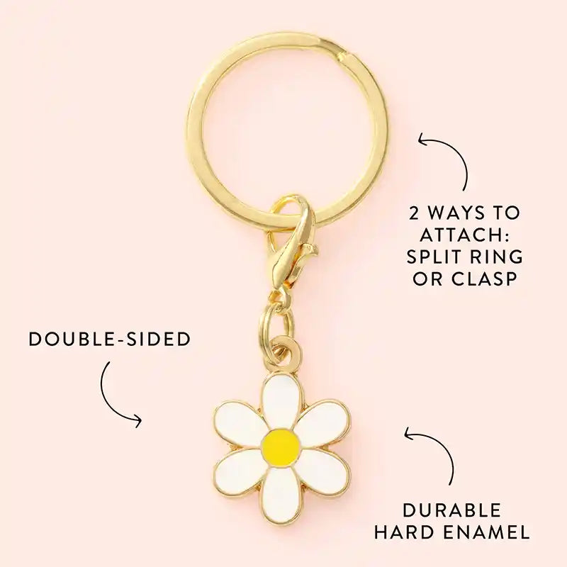 Keychain with a daisy charm on a pink background