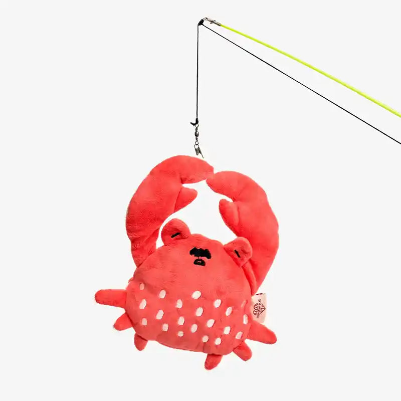 Plush crab toy on a fishing line against a white background