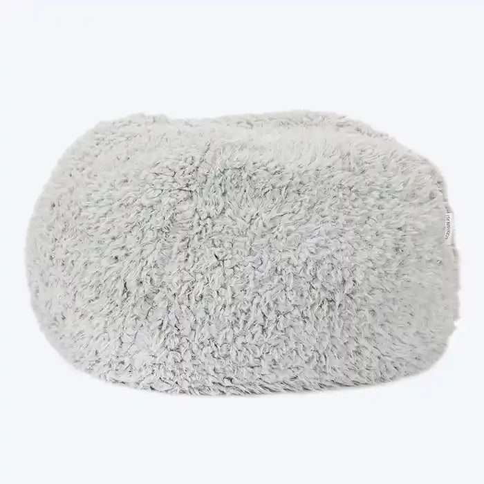 A grey, fluffy dog bed made of recycled fiber, designed to feel like a cloud.