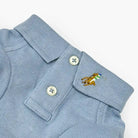 Light blue dog polo shirt collar and placket with two buttons and embroidered player logo.