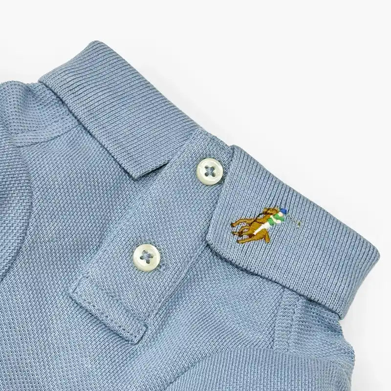 Light blue dog polo shirt collar and placket with two buttons and embroidered player logo.