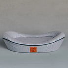 Navy and white striped pet bed with brand label on a grey background