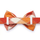 Back view of an orange plaid bowtie attached to a pet collar.