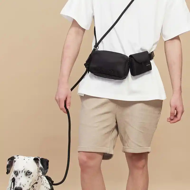 Man wearing a rover cross body dog leash with dalmation secured