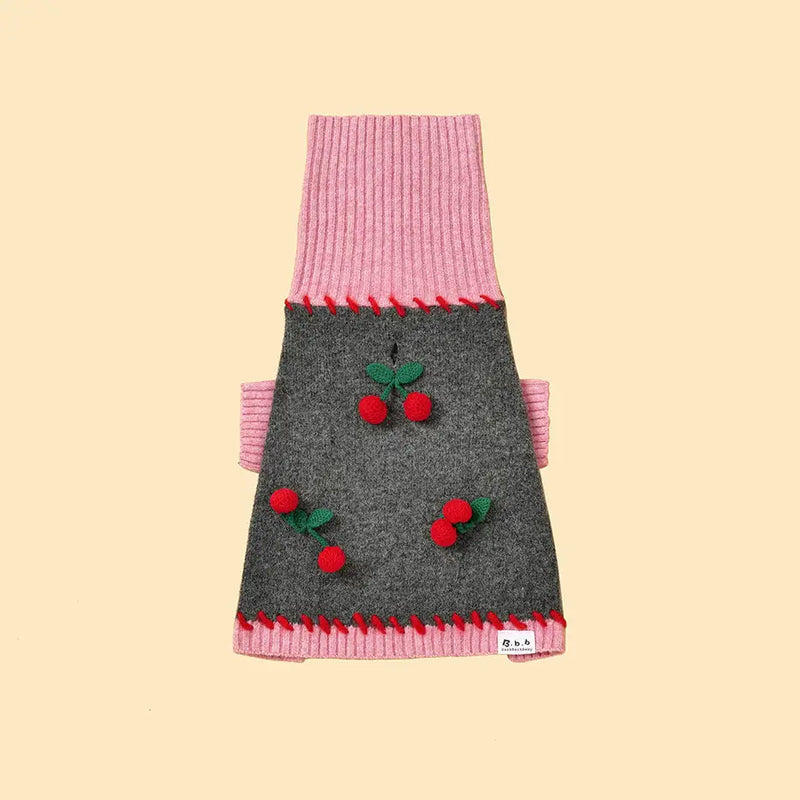 Dog sweater with pink and gray design and red cherries on a beige background