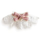 White lace pet bib with a pink bow and pearl accent.
