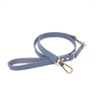 Blue dog leash with gold hardware on a white background