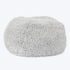 A grey, fluffy dog bed made of recycled fiber, designed to feel like a cloud.