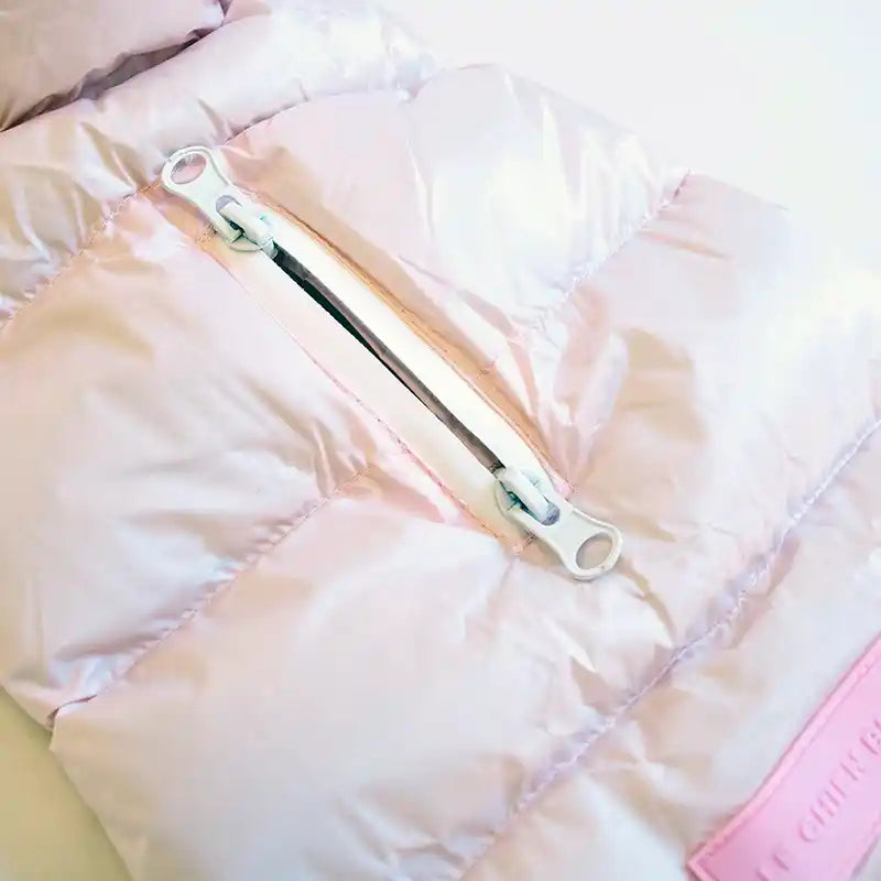 Close-up of a pink quilted jacket showing zipped leash/harness opening