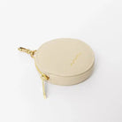 Beige treat pouch with gold zipper on a white background