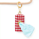 red gingham waste bag dispenser hanging on a leash