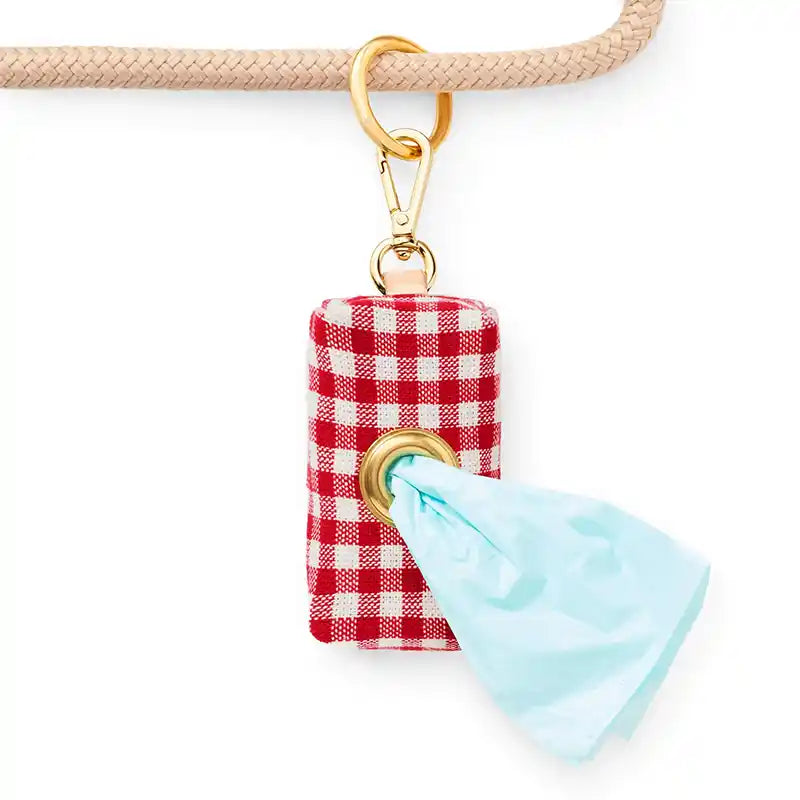red gingham waste bag dispenser hanging on a leash