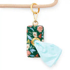Floral-patterned poo bag holder with a gold zipper hanging on a leash