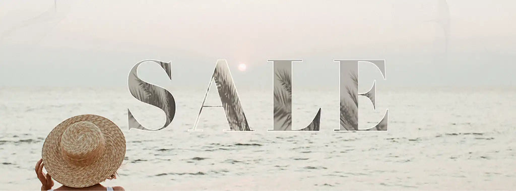 Person wearing a straw hat with 'SALE' text overlay on a beach.