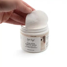 Hand reaching into a jar of 'Eye Envy' tear stain remover wipes on a white background