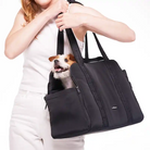woman holding black everywhere convertible dog tote